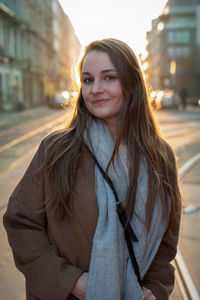 Portrait of smiling young woman standing in city