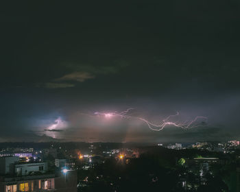 Illuminated city against sky at night
