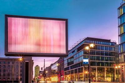 Illuminated buildings against sky at night