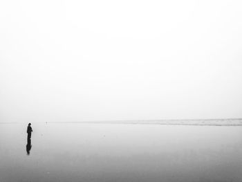Person on sea against clear sky