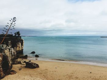 Scenic view of beach and sea against cloudy sky