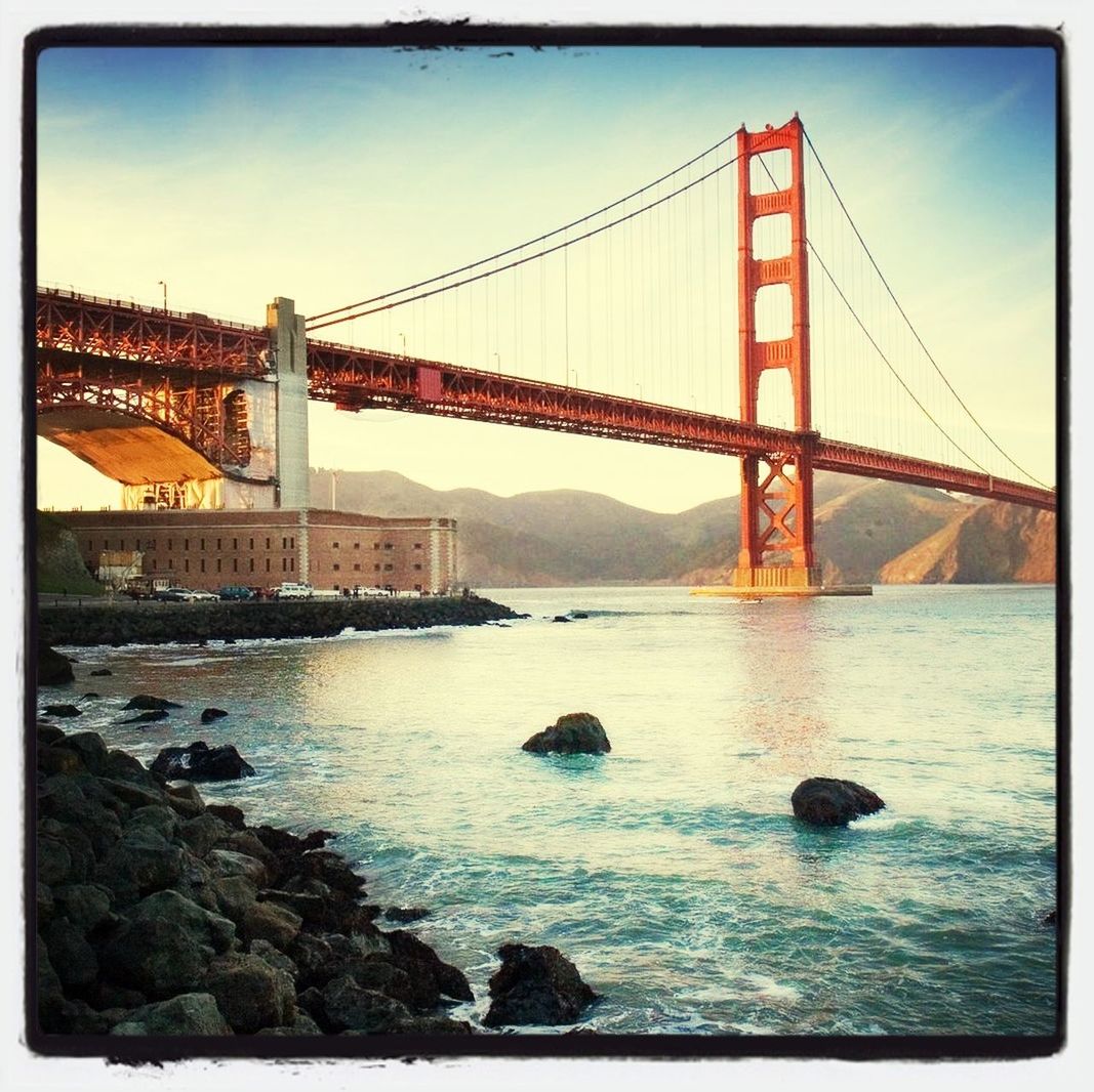 architecture, built structure, transfer print, connection, bridge - man made structure, water, suspension bridge, engineering, river, auto post production filter, bridge, international landmark, travel destinations, sky, famous place, golden gate bridge, transportation, travel, tourism, sea