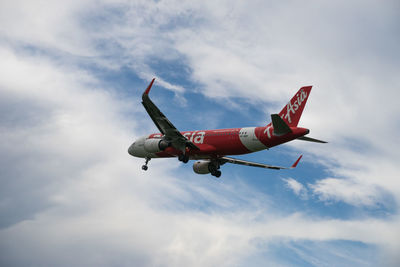 Low angle view of airplane flying against sky