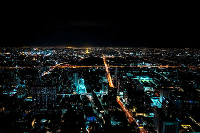 High angle view of city lit up at night