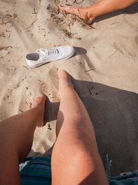 Low section of person relaxing on sand