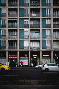 Cars on road by building in city