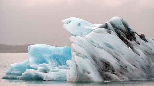 Frozen water in sea against sky