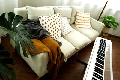 Low section of woman sitting on sofa at home