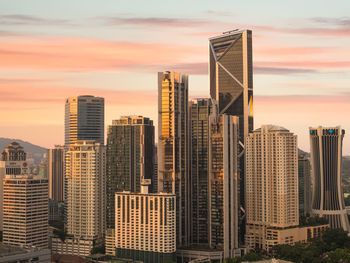 Modern buildings against sky during sunset