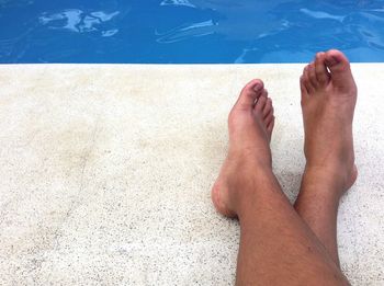 Low section of man legs in swimming pool