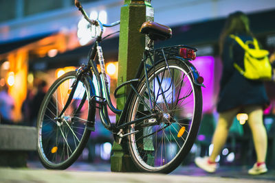 Close-up of bicycle leaning on bollard