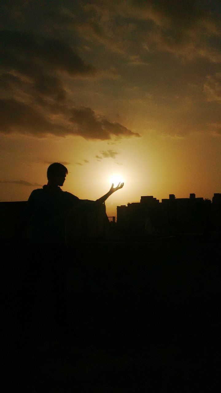SILHOUETTE MAN STANDING AGAINST ORANGE SUNSET SKY