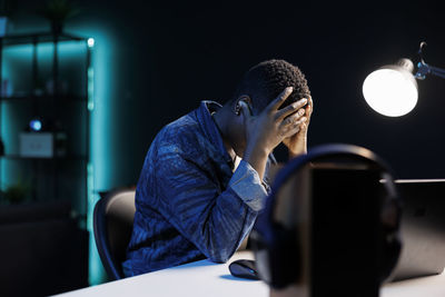 Side view of young man looking through window