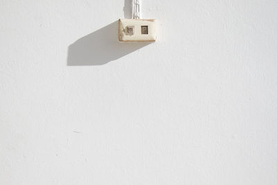 Close-up of electric lamp on white wall
