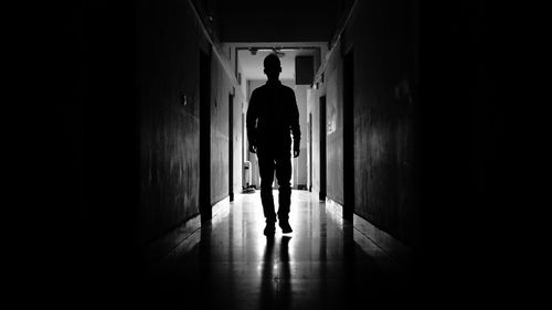 Silhouette man walking in corridor