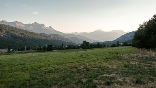 Scenic view of field and mountains against sky