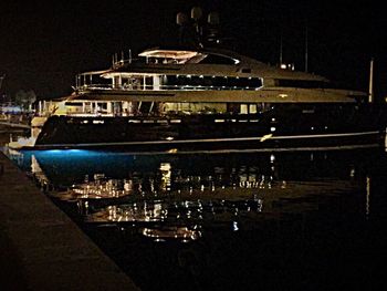 Illuminated boats moored in city at night