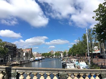 Bridge over river in city against sky