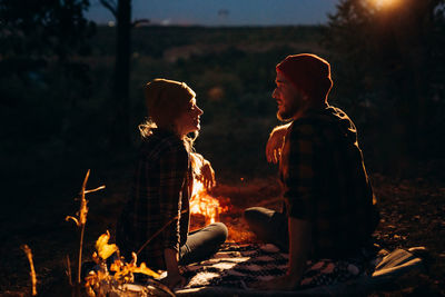 People sitting by bonfire