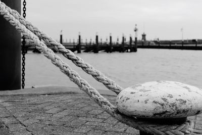 Close-up of rope tied up on bollard at harbor