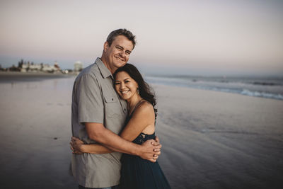 Portrait of happy friends standing at beach