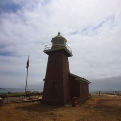 Lighthouse against cloudy sky