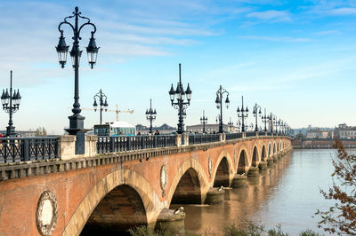 Scenic view of bridge over river against cloudy sky