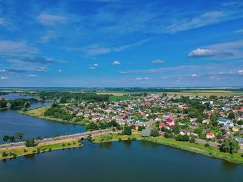 Scenic view of river by buildings against blue sky