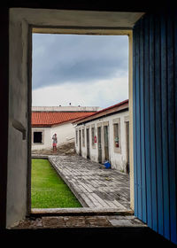 Buildings against sky seen through window