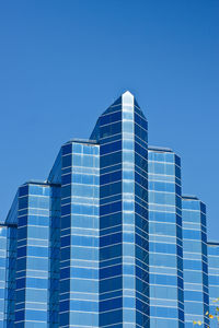 Low angle view of modern building against clear blue sky