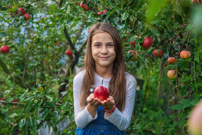 Portrait of young woman holding apples