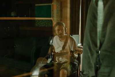 Man playing guitar at home