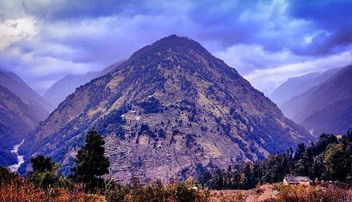 Scenic view of mountains against cloudy sky