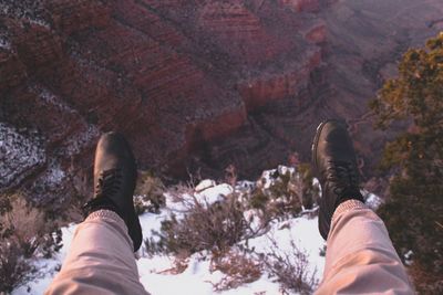 Low section of man on snowcapped mountain in forest