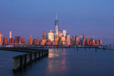 Illuminated buildings in city at waterfront