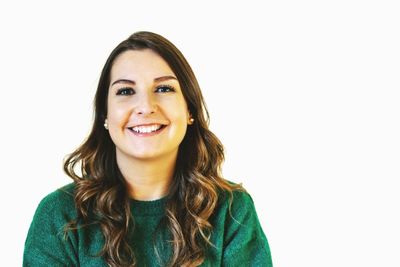 Portrait of smiling young woman against white background