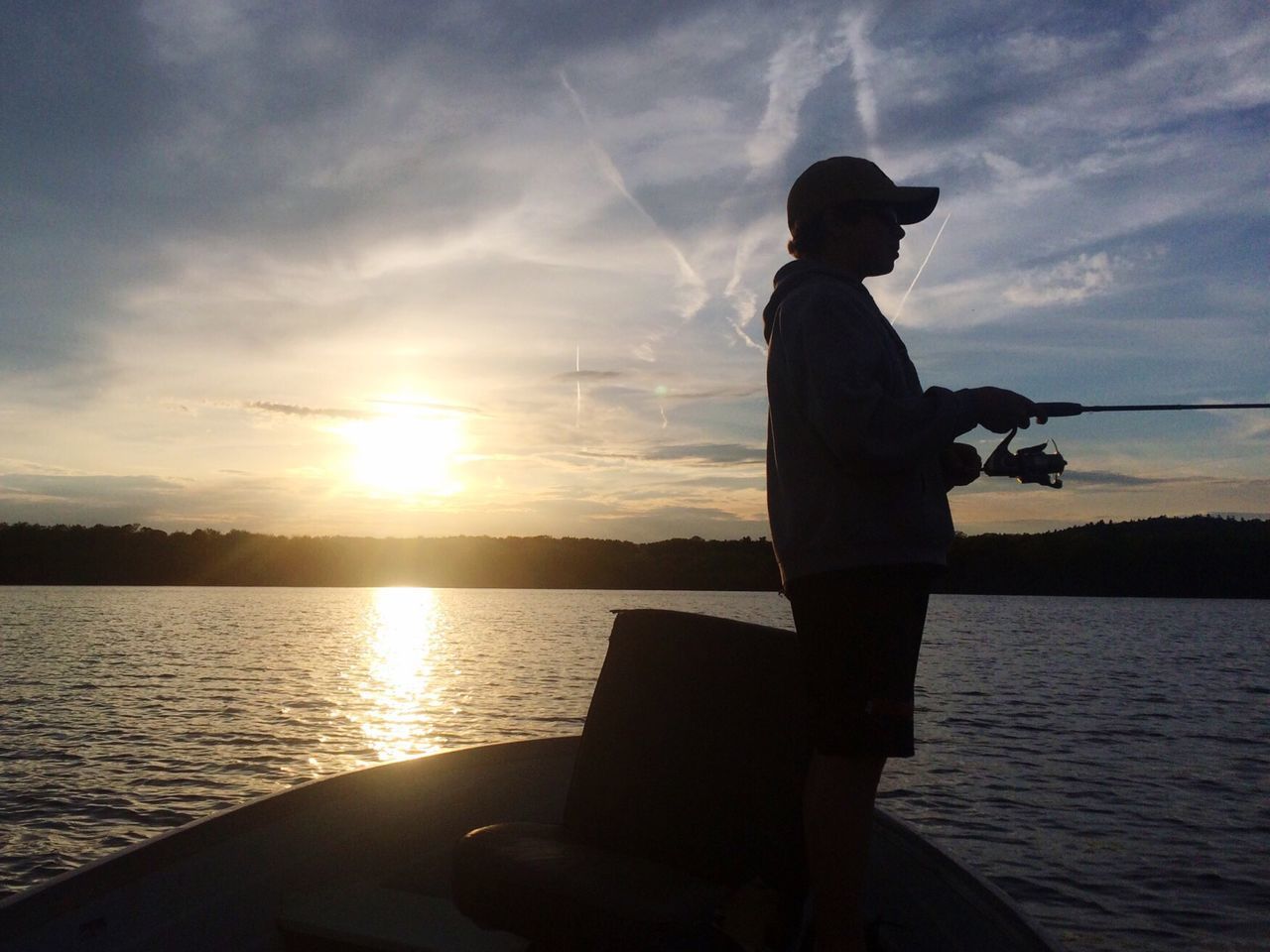 SILHOUETTE BOY FISHING IN SEA AGAINST SKY