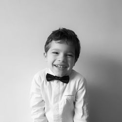 Portrait of smiling boy standing against white background