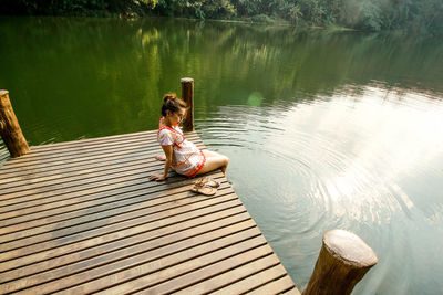 Woman sitting by lake