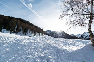 Scenic view of snow covered field against sky