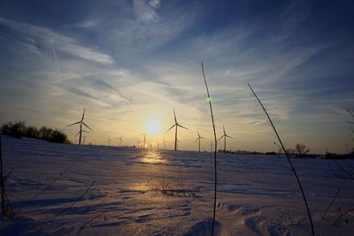 Scenic view of snow covered land against sky during sunset