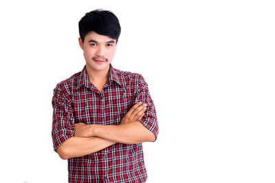 Portrait of young man standing against white background