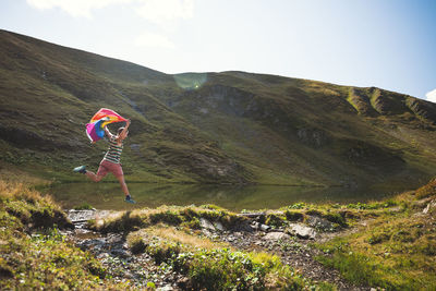 Man with lgbtiq community flag in mountains