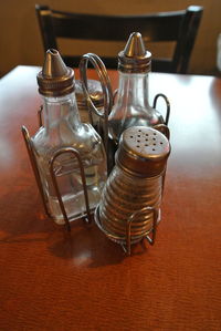 Close-up of bottles with pepper shaker on table