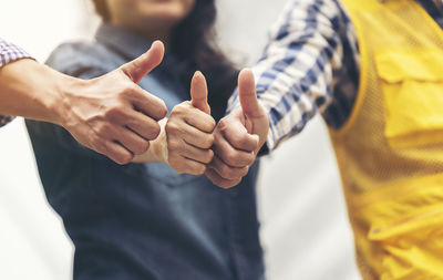 Cropped image of engineers gesturing thumbs up sign