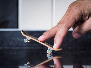 Close-up of person fingers on toy skateboard