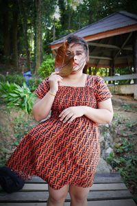 Full length of woman wearing hat standing against plants