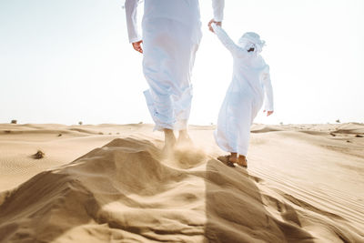 Rear view of people walking on beach