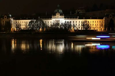 Reflection of illuminated building in river at night