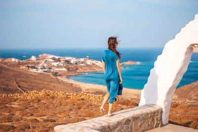 Woman standing on beach against sky